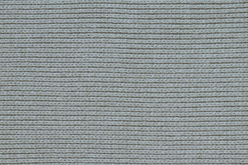 The texture of a light knitted sweater fabric.
