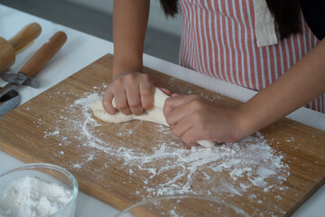 Asian girl learning cooking with mother in the kitchen