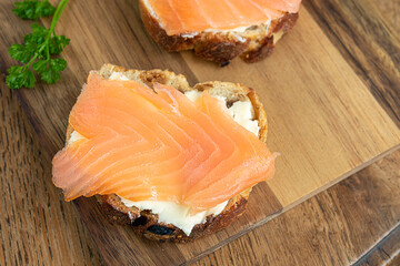 Salmon toasts with cream cheese on the fig bread, healthy food and fish sandwich concept. top view