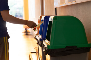 Young Asian men dump cans or plastic bottles in sorting bins for recycling, Garbage sorting and disposal, Environmental Love Project.