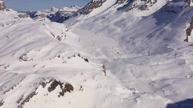 Aerial footage of the Gemmi pass on a sunny winter day above the Leukerbad village that links the Cantons of Valais and Bern in the alps in Switzerland