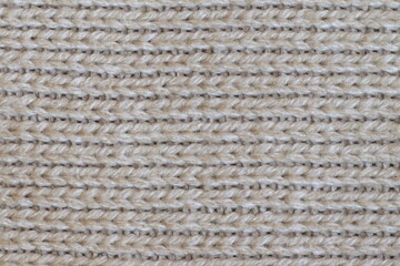 The texture of a light knitted sweater fabric.
