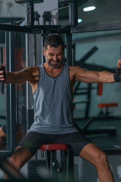Mature trainer athlete working out chest muscles doing strength training exercises on gym benchpress equipment.