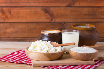 cottage cheese, milk and rustic sour cream on a wooden table
