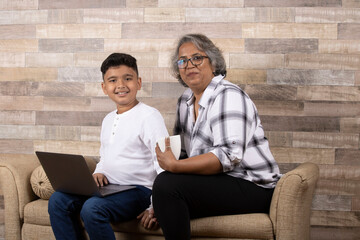 Happy moments with grandma, indian or asian senior lady spending quality time with her grand son using laptop