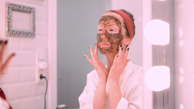 Woman cosmetic facial skin care. Woman in skin rubber peeling face beauty mask.