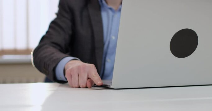 A man in a suit holds an access flash drive key in his hand, inserts the key into a laptop, unlocks it with a fingerprint. Electronic data protection system on the computer