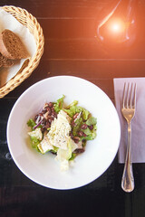 Kidney beans health salad. Dark table and white plate. Cafe menu. Green leaves and cheese fitness dinner. Organic vegetable diet. Black bread bowl. Vegan product. Fast eat. Flatlay. Top View