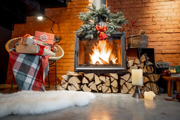 Burning fireplace decorated with a presents and New Year's wreath at cozy home interior