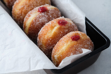 Traditional German Polish Donut with Raspberry Jam Dusted with Sugar. The traditional meal on Fat...