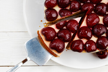 Closeup homemade cake with cherries on white wooden table. Top view.