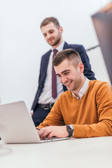 Picture of a businessman working on some final financial details with a suited manager standing next to him