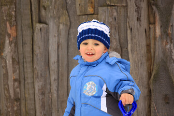 little boy in winter clothes with a child shovel, close-up portrait