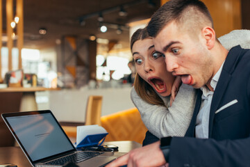 Couple having fun in a cafe ( coffee shop) while making crazy faces and fooling around