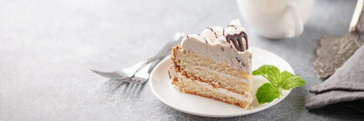 Cake with cream and a decor on a table, a dessert to tea. Selective focus.