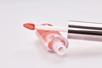 Tube of liquid lipstick gloss with applicator isolated on white background
