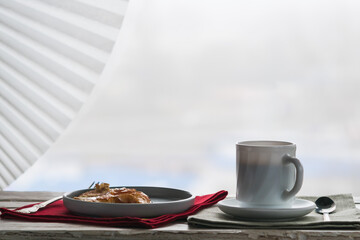 A cup of coffee and a plate of pancakes on a decorative table