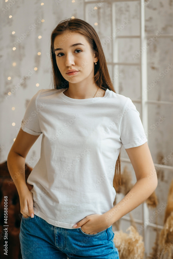 Wall mural stylish girl wearing white t-shirt posing in studio - Wall murals