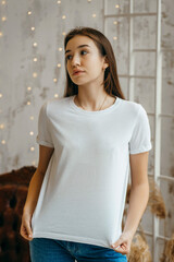 Fototapeta premium Stylish girl wearing white t-shirt posing in studio
