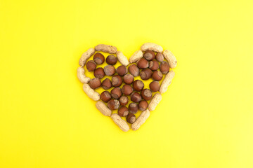 Heart lined with nuts on a yellow background