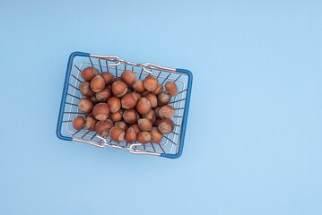 Grocery basket with hazelnuts on a blue background
