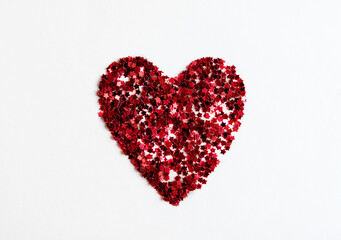 Greeting card heart made of red confetti on a white background.