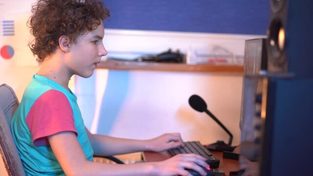 Troubled teens. Young boy with gaming headphones looking frustrated at monitor. Video Gamer playing a videogame. A nerdy boy gaming online