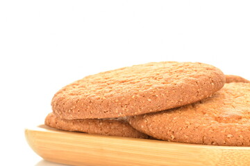 Several freshly baked round American cookies in a bamboo dish, close-up, isolated on white.