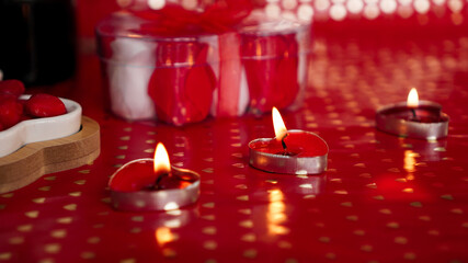 Obraz na płótnie Canvas Candles for valentines day, table with festive red background.