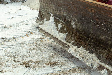grader cleaning asphalt raod from ice and snow winter transportation problems