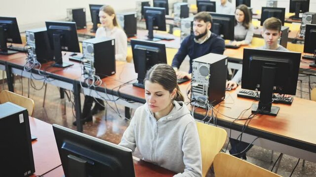 Group of people of different ages learning to use computers in classroom