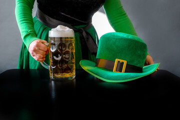 St Patricks day glass beer hand hold costume hat leprechaun black background