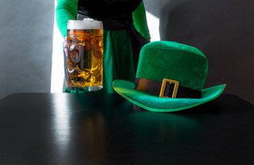 St Patricks day glass beer hand hold costume hat leprechaun black background