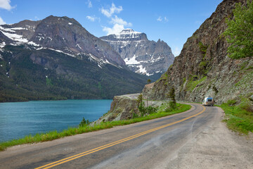 Camper travels alongside St Mary's Lake and mountains in Glacier National Park