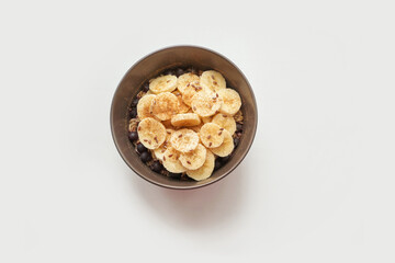 Healthy breakfast. Top view. Oatmeal with banana and flax seeds at bowl. Berry in plate. Organic meal recipe. Vegan cook. Minimalism granola. Hot porrigde with fruit