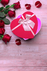 Open heart shaped boxes lovers' gifts on wooden surface, roses, petals. Valentine's day 14 february or romantic evening invitation,  postcard, poster, decoration.