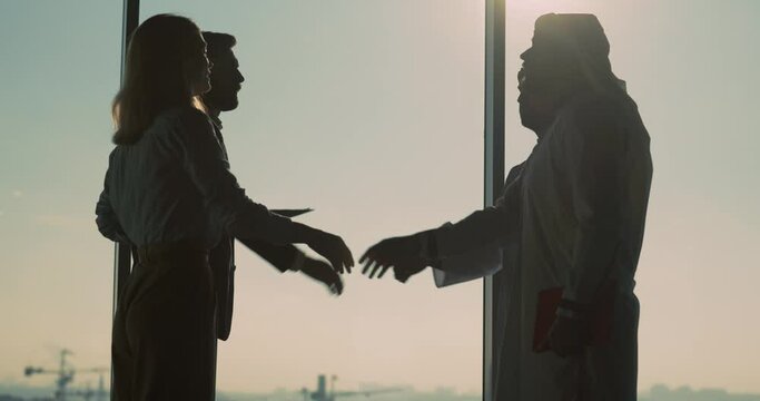 Couples of financial managers and arabian investors shaking hands to agreement collaborating in corporate company office. Investment meeting.