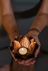 woman holding a lotus-shaped candlestick with a candle