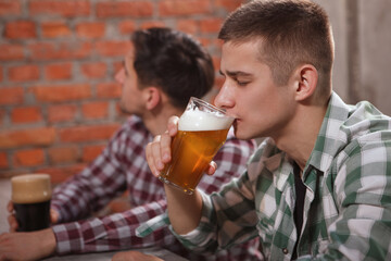 Young man sipping delicious beer at the pub