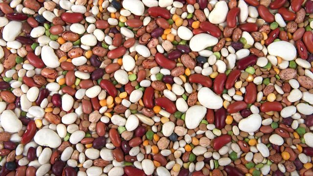 HD video above zooming in on background of fifteen beans varieties for bean salad or soup
