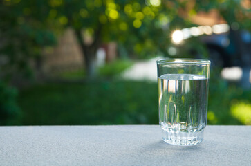 Drinking water glass against the background of green nature.