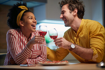 Delightful mixed couple relaxing and drinking wine together