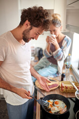 Boyfriend preparing a breakfast for his girlfriend. Cooking, together, kitchen, relationship