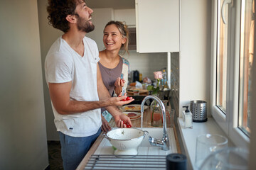 A young couple in love joking while preparing a breakfast together. Relationship, together, kitchen, love