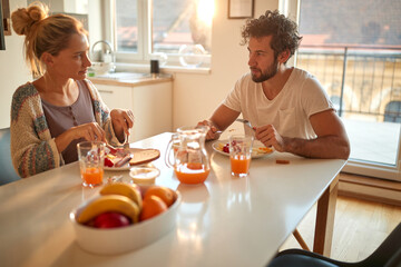 A young couple having a breakfast at home together. Relationship, love, together, breakfast