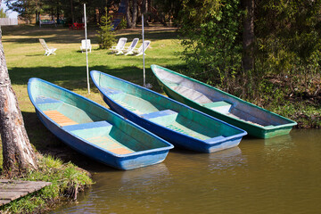 Three blue boats on the shore of the lake