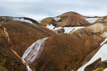 Landmannalaugar National Park. River flowing through colorful slopes of the rhyolite mountains. Iceland adventure hiking Laugavegur trail to Landmannalaugar.