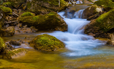 Fototapeta na wymiar small waterfall on the rushing mountain river