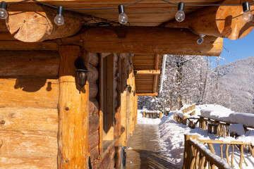 Snow-covered wooden house in the mountains in winter