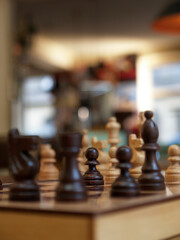wooden chessboard with the chess pawn in focus and a blurred background
